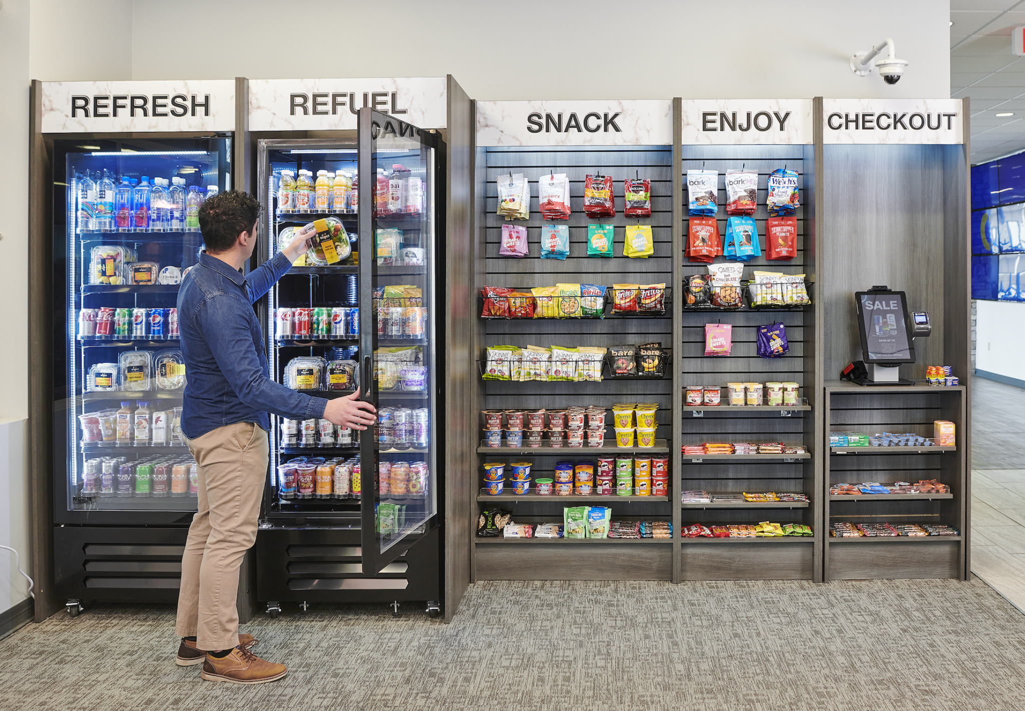 Open micro market with refrigerated merchandisers, snacks, and checkout area
